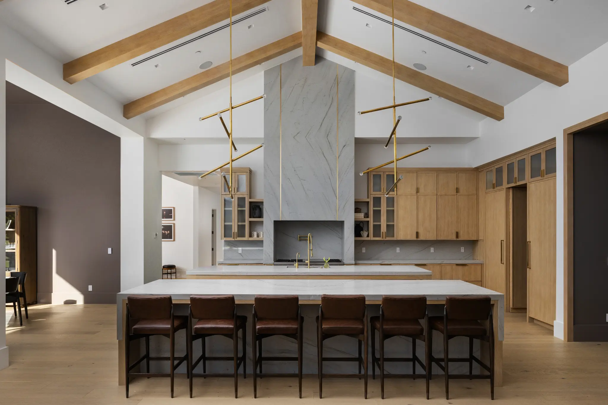 High-volume kitchen with cathedral ceiling, stone hood surround, and custom light oak cabinetry